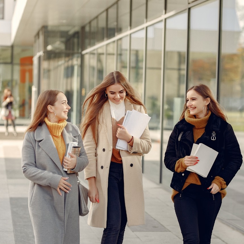 Young students on a student campus standing with a documents